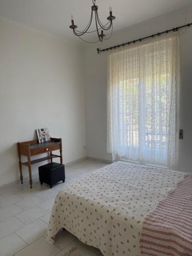 a bedroom with a bed and a table and a window at VILLA PROCHE de la PLAGE, VUE MER avec PARKING in LʼÎle-Rousse