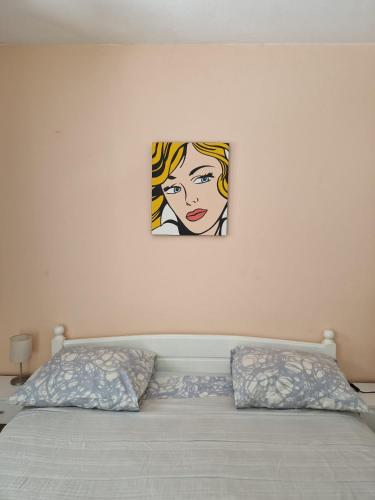 a painting of a woman on a wall above a bed at Apartments Adriatic in Korčula