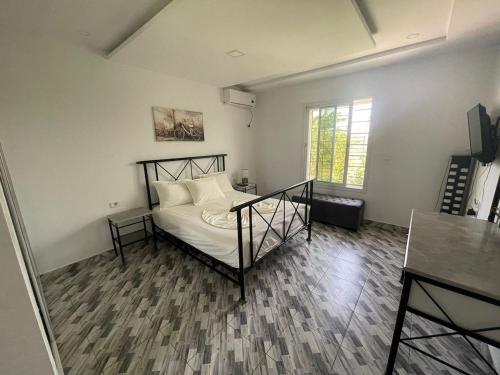a bedroom with a bed with white sheets and a window at Dar Nawara 3bedroom Villa with pool and amazing garden in Tazarka