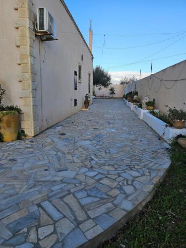 a stone walkway next to a building at Dar Nawara 3bedroom Villa with pool and amazing garden in Tazarka