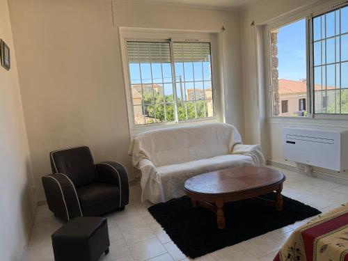 a living room with a couch and a chair and a table at VILLA PROCHE de la PLAGE, VUE MER avec PARKING in LʼÎle-Rousse