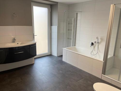 a bathroom with a tub and a sink and a shower at Mosel-Wohnen II - FERIENLAND COCHEM - Ellenz-Poltersdorf in Ellenz-Poltersdorf