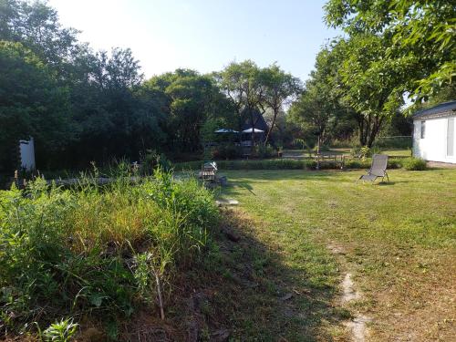 a yard with two chairs and a bench in the grass at Farm Ház in Fonyód