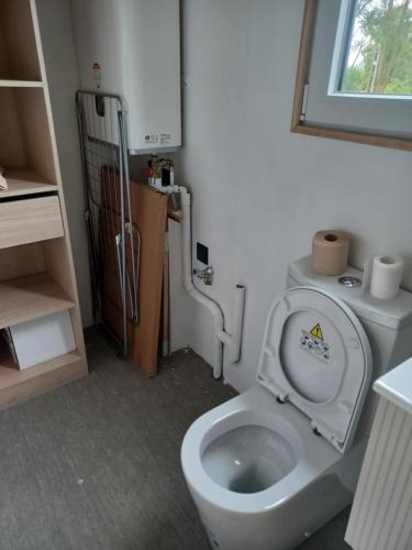 La salle de bains est pourvue de toilettes avec un couvercle. dans l'établissement Le Refuge Des Loups, à Biziat