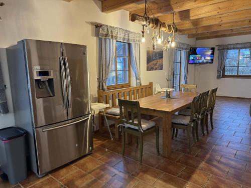 a kitchen with a wooden table and a refrigerator at Chalupy Jesenická dvojčata in Šumperk