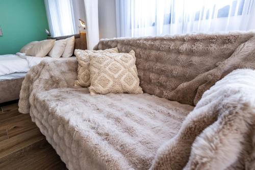 a couch with pillows on it in a living room at צימר נחלים - בקיבוץ הגושרים in Hagoshrim