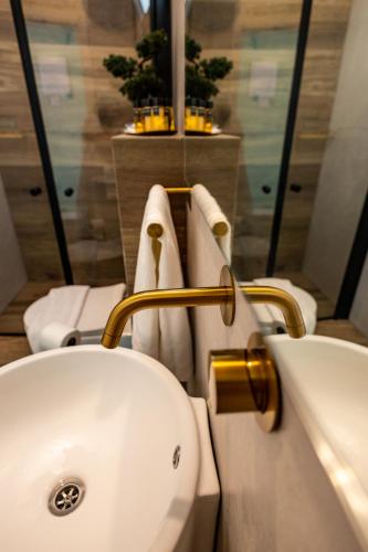 a bathroom with a sink and a toilet with towels at צימר נחלים - בקיבוץ הגושרים in Hagoshrim