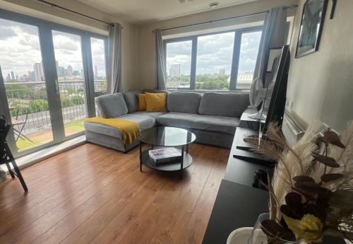 a living room with a couch and a large window at Sunset Heights Bright 2BR with City Views and Free Parking in London