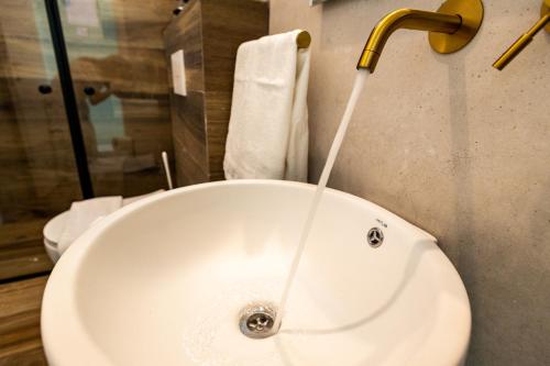 a sink with water running from a faucet in a bathroom at צימר נחלים - בקיבוץ הגושרים in Hagoshrim