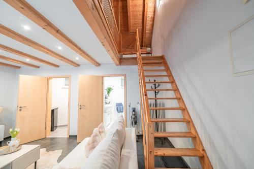 a living room with a couch and a wooden staircase at Stilvolle Ferienwohnung in Immenstadt zentral & mit Parkplatz in Immenstadt im Allgäu