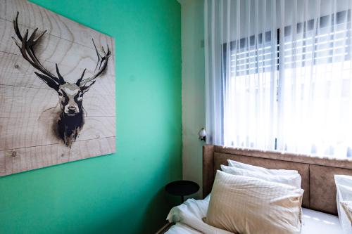a bedroom with a painting of a deer head on the wall at צימר נחלים - בקיבוץ הגושרים in Hagoshrim
