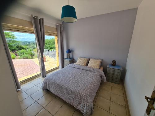 une chambre avec un lit et une grande fenêtre dans l'établissement Sarlat appartement, à Sarlat-la-Canéda