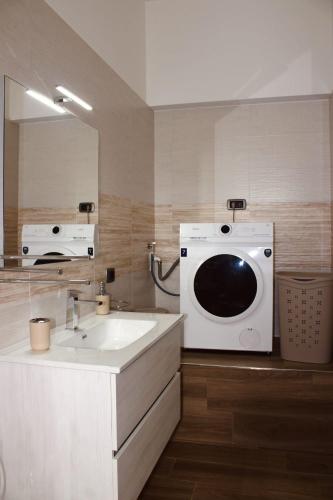 a bathroom with a sink and a washing machine at Carpe Diem Casa Vacanze in Massafra