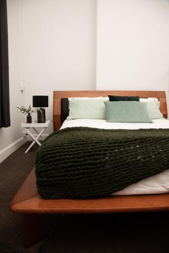 a bedroom with a bed with a black blanket on it at The Glen Farmhouse on Ovens River in Wangaratta