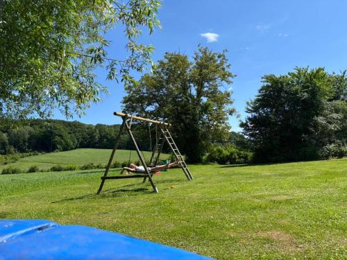 a person laying on a swing in a field at Perschlingtalhof in Auern