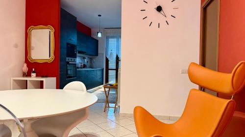 ein Esszimmer mit einem weißen Tisch und orangefarbenen Stühlen in der Unterkunft Casa SUN in Civitanova Marche