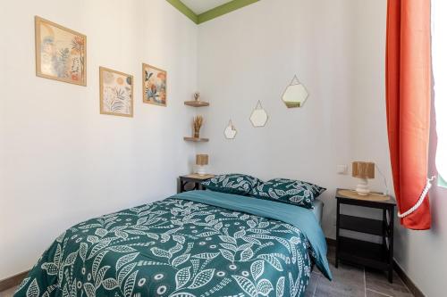 - une chambre avec un lit et une couette verte et blanche dans l'établissement Appartements proche de la gare, à Narbonne