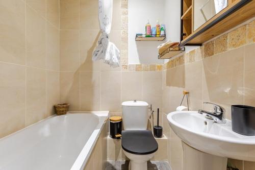 une salle de bain avec une baignoire, des toilettes et un lavabo dans l'établissement Appartements proche de la gare, à Narbonne