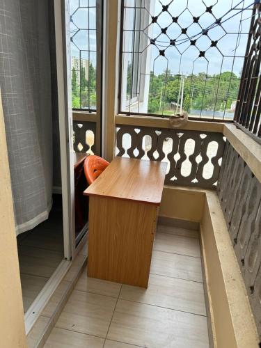 a balcony with a wooden table in front of a window at Comfy Stays in Mombasa