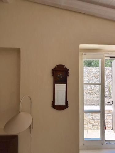 a clock on a wall next to a window at Dodo darling in Oziás