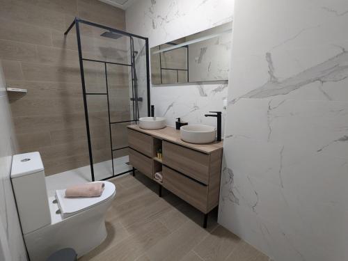 a bathroom with two sinks and a toilet in it at Alojamiento huerto Altabix in Elche