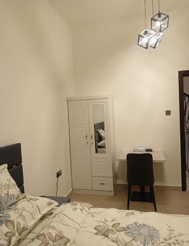 a bedroom with a bed and a desk and a chair at Cozy Beautiful Private Room with Shared Washroom in Ajman 
