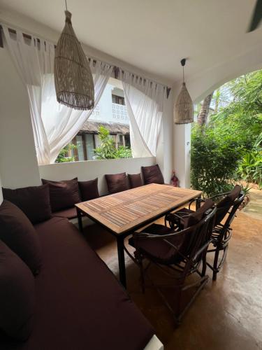 a living room with a wooden table and chairs at Siri Beach Lodge in Nungwi