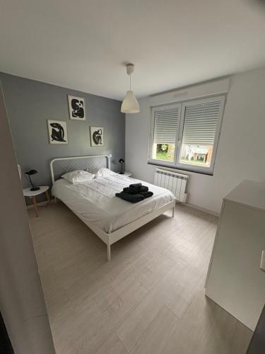 - une chambre avec un lit blanc et 2 fenêtres dans l'établissement La Petite Baie, à Pleine-Fougères