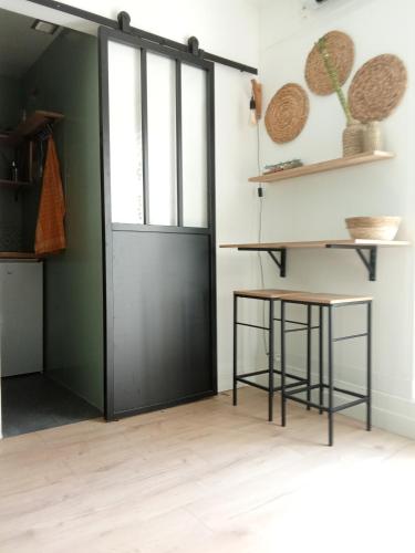 une porte dans une pièce avec une table et des raquettes de tennis dans l'établissement A secret garden in Montmartre, à Paris