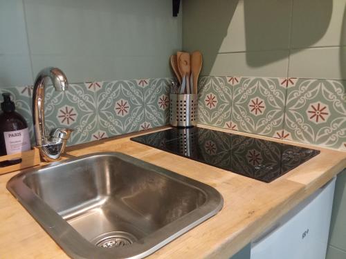 - un évier en acier inoxydable dans une cuisine avec un comptoir dans l'établissement A secret garden in Montmartre, à Paris