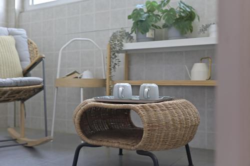 a rattan chair with a table with two mugs on it at Gongxi Home Plus Bell Tower Big Wild Goose Pagoda Tangcheng Terra Cotta Warriors6 metro away from Xian North Railway Station 3 minutes walk to Line 2 100 inch projection free trial service in Xi'an