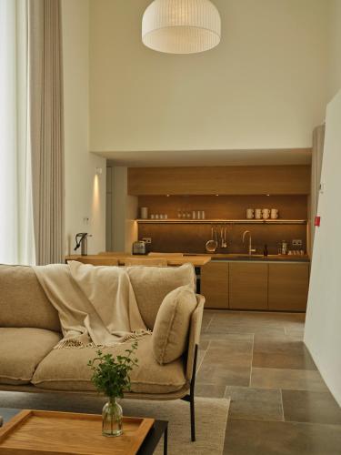 a living room with a couch and a kitchen at Fowlescombe Farm in Ugborough