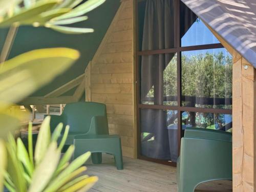 a room with two chairs and a large window at Hostel & Glamping Santa Fortunata in Sorrento