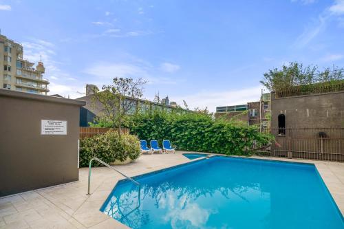 a swimming pool on the roof of a building at Inner City Harbour Views With Parking in Sydney