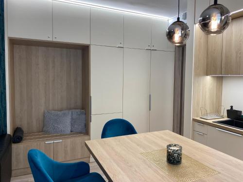 a kitchen with a wooden table and blue chairs at Nekem Füred in Balatonfüred