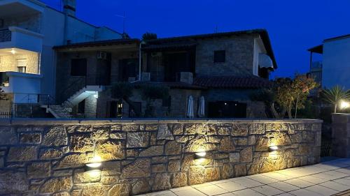 a stone wall in front of a house at night at Studio Greek Mansion in Nea Moudania