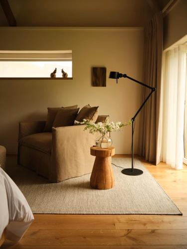 a living room with a couch and a table with a lamp at Fowlescombe Farm in Ugborough