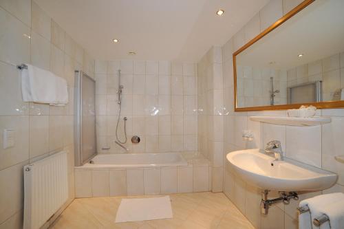 a bathroom with a tub and a sink and a shower at Vital Hotel Ortlerspitz in San Valentino alla Muta