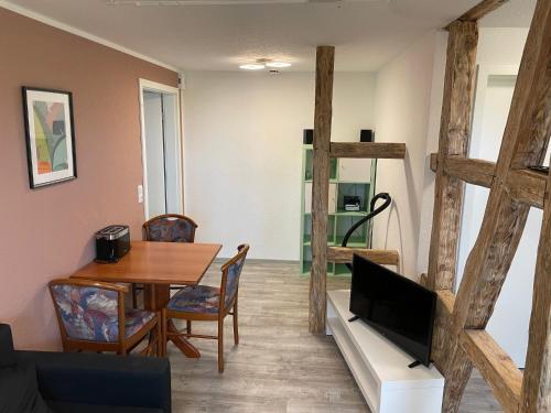a living room with a table and a tv at Stellmann’s Gästehof in Bruchhausen-Vilsen