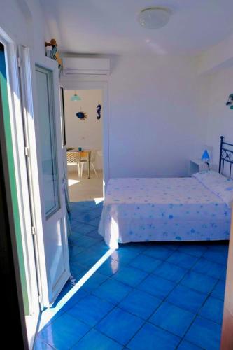 a bedroom with a bed and a blue tiled floor at PonzaSmeralda Le Forna in Ponza