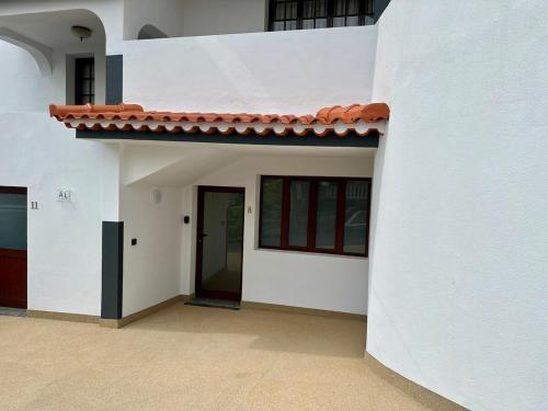 a white building with a red roof and a door at Anita & Leonel's House B in Gaula