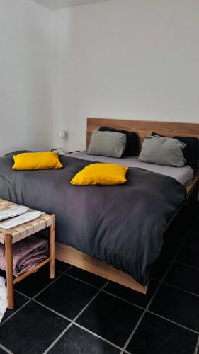 a large bed with two yellow pillows on it at Au coron des Anges - Havré - Mons - Pairi Daiza - Shape in Mons