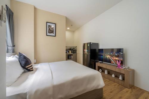 a bedroom with a bed and a flat screen tv at Manuka Home in Ho Chi Minh City