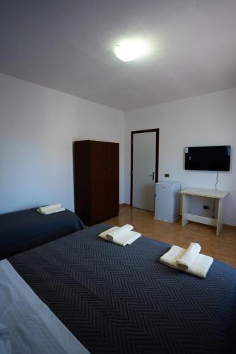 a bedroom with two beds and a flat screen tv at Ela's apartment 1 in Durrës