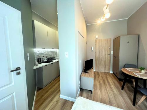 un piccolo appartamento con cucina e tavolo di GREY Apartment 1 a Poznań