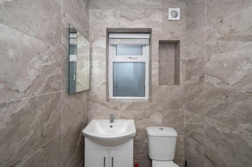 a bathroom with a sink and a toilet and a window at Charming City Retreat in Cork in Cork