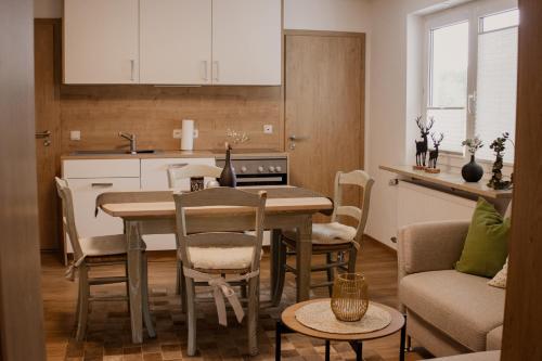 une cuisine et un salon avec une table et des chaises dans l'établissement Idyllisch gelegene Ferienwohnung Xaver im Herzen des bayerischen Waldes, à Zachenberg
