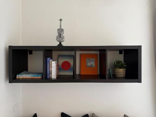 une étagère noire sur un mur avec des livres dans l'établissement Au Carmes 1D joli T2 meublé et wifi, à Avignon