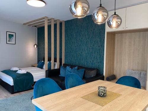 a room with a bed and a table and blue chairs at Nekem Füred in Balatonfüred