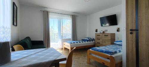 a small room with two beds and a window at Pokoje Jadwiga Konkel in Jastarnia